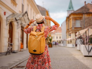 Varazdin sokaklarında yaz günü eski, tarihi şehir merkezinde yürüyen güzel bir kadın. Bu güzel caddeleri keşfeden turist, Hırvat kentinin rahat ve kültürel havasını yaşıyor..