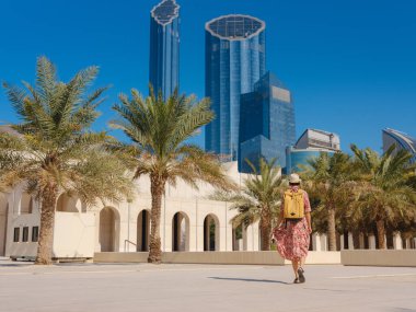 Abu Dabi 'de Qasr Al Hosn Parkı' nı keşfeden genç bir kadın. Yeşillik ve tarihi simgelerle çevrelenmiş, kentin kalbindeki sakin atmosfer ve Emirati mirasının tadını çıkarıyor..