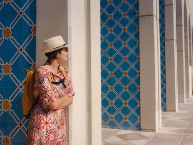 Abu Dabi 'de Qasr Al Hosn Parkı' nı keşfeden genç bir kadın. Yeşillik ve tarihi simgelerle çevrelenmiş, kentin kalbindeki sakin atmosfer ve Emirati mirasının tadını çıkarıyor..