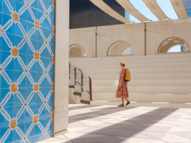 Abu Dabi 'de Qasr Al Hosn Parkı' nı keşfeden genç bir kadın. Yeşillik ve tarihi simgelerle çevrelenmiş, kentin kalbindeki sakin atmosfer ve Emirati mirasının tadını çıkarıyor..