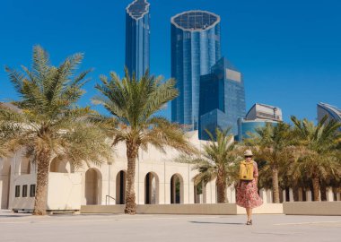 Abu Dabi 'de Qasr Al Hosn Parkı' nı keşfeden genç bir kadın. Yeşillik ve tarihi simgelerle çevrelenmiş, kentin kalbindeki sakin atmosfer ve Emirati mirasının tadını çıkarıyor..