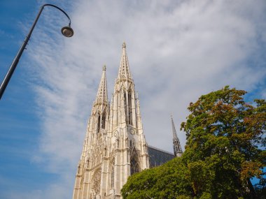 Viyana 'da güzel bir yaz tatili - Vatandaş Kilisesi Neo-Gotik Avusturya Kilisesi. Yaz yürüyüşü, tarihi sokakları keşfetmek, çarpıcı mimari, güneş ışığı altındaki canlı şehir atmosferi..