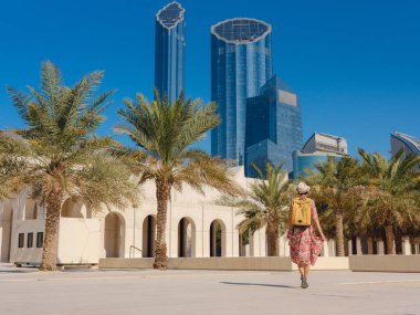 Abu Dabi 'de Qasr Al Hosn Parkı' nı keşfeden genç bir kadın. Yeşillik ve tarihi simgelerle çevrelenmiş, kentin kalbindeki sakin atmosfer ve Emirati mirasının tadını çıkarıyor..