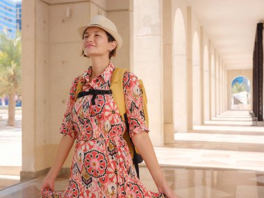 Abu Dabi 'de Qasr Al Hosn Parkı' nı keşfeden genç bir kadın. Yeşillik ve tarihi simgelerle çevrelenmiş, kentin kalbindeki sakin atmosfer ve Emirati mirasının tadını çıkarıyor..