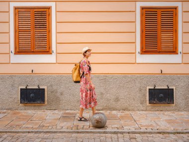 Varazdin sokaklarında yaz günü eski, tarihi şehir merkezinde yürüyen güzel bir kadın. Bu güzel caddeleri keşfeden turist, Hırvat kentinin rahat ve kültürel havasını yaşıyor..