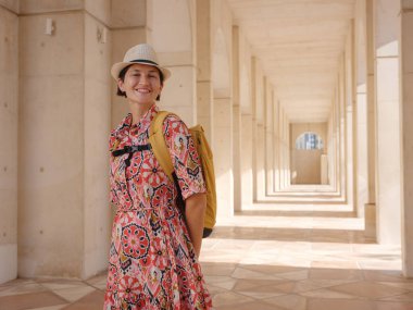 Abu Dabi 'de Qasr Al Hosn Parkı' nı keşfeden genç bir kadın. Yeşillik ve tarihi simgelerle çevrelenmiş, kentin kalbindeki sakin atmosfer ve Emirati mirasının tadını çıkarıyor..