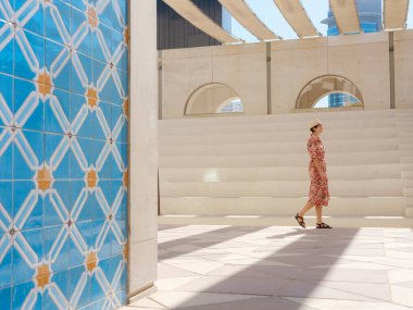 Abu Dabi 'de Qasr Al Hosn Parkı' nı keşfeden genç bir kadın. Yeşillik ve tarihi simgelerle çevrelenmiş, kentin kalbindeki sakin atmosfer ve Emirati mirasının tadını çıkarıyor..