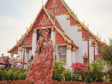 Ayutthaya, Tayland 'a git. Genç bayan turist, canlı mimari ve kültürel sembollerle çevrili modern Budist tapınaklarını keşfediyor, maneviyat ve Tayland mirasının özünü yakalıyor..