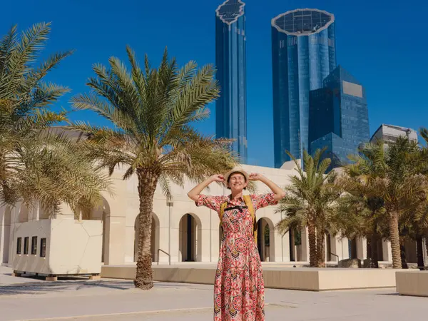 Abu Dabi 'de Qasr Al Hosn Parkı' nı keşfeden genç bir kadın. Yeşillik ve tarihi simgelerle çevrelenmiş, kentin kalbindeki sakin atmosfer ve Emirati mirasının tadını çıkarıyor..