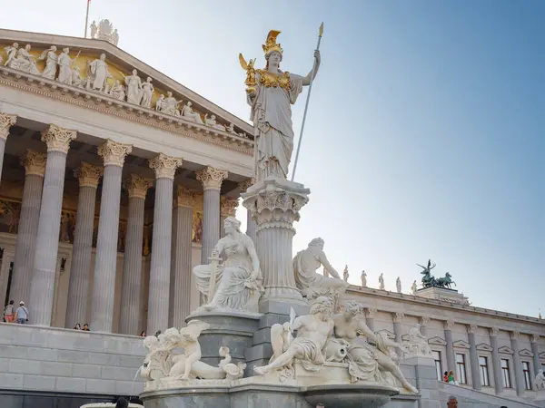 Viyana, Avusturya - 10 Temmuz 2023 Pallas Athena Çeşmesi. Demokrasinin simgesel bir sembolü olan Majestic Avusturya Parlamento Binası canlı şehir manzarasına karşı sıcak güneş ışığında ele geçirildi..