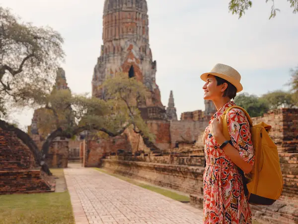 Tayland 'ın Ayutthaya kentinde tarihi parkı keşfetmek için giyinmiş genç bir bayan turist. Antik tapınaklar ve heykellerle çevrili, huzurlu bir atmosfer ve zengin kültürel mirasın tadını çıkarıyor..