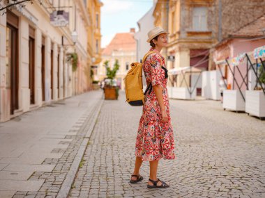 Varazdin sokaklarında yaz günü eski, tarihi şehir merkezinde yürüyen güzel bir kadın. Bu güzel caddeleri keşfeden turist, Hırvat kentinin rahat ve kültürel havasını yaşıyor..