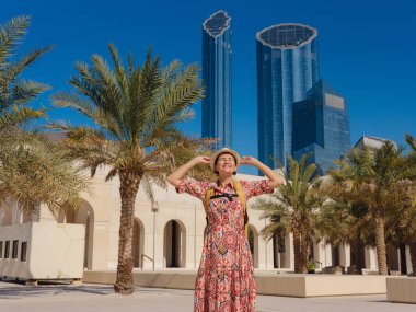 Abu Dabi 'de Qasr Al Hosn Parkı' nı keşfeden genç bir kadın. Yeşillik ve tarihi simgelerle çevrelenmiş, kentin kalbindeki sakin atmosfer ve Emirati mirasının tadını çıkarıyor..