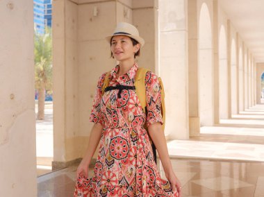 Abu Dabi 'de Qasr Al Hosn Parkı' nı keşfeden genç bir kadın. Yeşillik ve tarihi simgelerle çevrelenmiş, kentin kalbindeki sakin atmosfer ve Emirati mirasının tadını çıkarıyor..