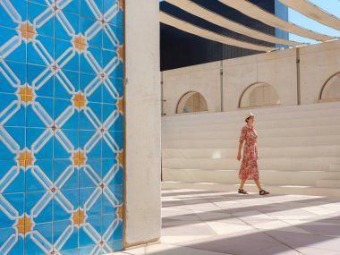 Abu Dabi 'de Qasr Al Hosn Parkı' nı keşfeden genç bir kadın. Yeşillik ve tarihi simgelerle çevrelenmiş, kentin kalbindeki sakin atmosfer ve Emirati mirasının tadını çıkarıyor..