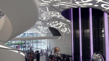 Dubai, BAE - 16 Ocak 2024: Geleceğin Müzesi 'nin modern iç kesimlerinden keyif alan turistler. Modern fütüristik müze mimar Shaun Killa tarafından tasarlandı..