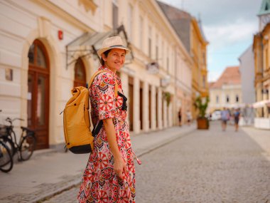 Varazdin sokaklarında yaz günü eski, tarihi şehir merkezinde yürüyen güzel bir kadın. Bu güzel caddeleri keşfeden turist, Hırvat kentinin rahat ve kültürel havasını yaşıyor..