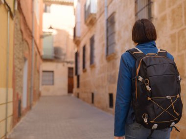 İspanya 'nın Alicante eyaletinin büyüleyici dar sokaklarında gezinen, tarihi Akdeniz mimarisi ile çevrili, barışçıl atmosfer ve kültürel ortamın tadını çıkaran genç bir kadın..