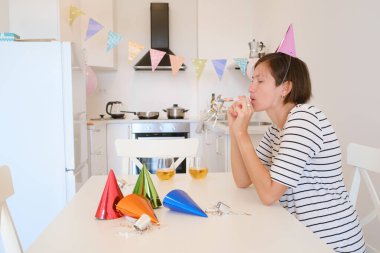 Genç çift sıcak bir ortamda pasta ve kahkahaların tadını çıkararak evde rahat bir doğum günü kutluyor. Aile makarna yiyor ve şarap içiyor. Kutlamak için, afiyet olsun ve şerefe.