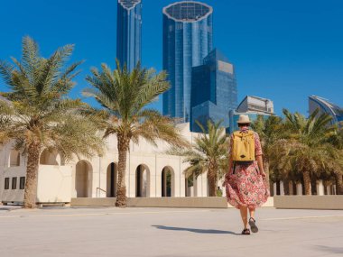 Abu Dabi 'de Qasr Al Hosn Parkı' nı keşfeden genç bir kadın. Yeşillik ve tarihi simgelerle çevrelenmiş, kentin kalbindeki sakin atmosfer ve Emirati mirasının tadını çıkarıyor..
