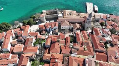 Krk Adası 'ndaki tarihi kıyı kasabası, dolambaçlı caddelerde, marinada ve şehir duvarlarında güneş ışığının Adriyatik Denizi' ne yansıdığı eski taş evler. Nefes kesici hava manzarası,