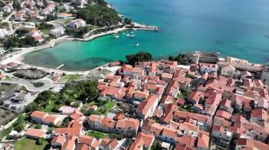 Krk Adası 'ndaki tarihi kıyı kasabası, dolambaçlı caddelerde, marinada ve şehir duvarlarında güneş ışığının Adriyatik Denizi' ne yansıdığı eski taş evler. Nefes kesici hava manzarası,
