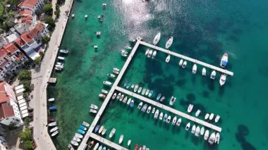 Baska plajı ve kristal berraklığında turkuaz su, marina botları, şehir sokağı, Krk Adası 'ndaki insansız hava aracından yakalanan güneşli yaz havası. Adriyatik Denizi 'ndeki Baska Tatil Kasabası