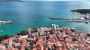 Krk Adası 'ndaki tarihi kıyı kasabası, dolambaçlı caddelerde, marinada ve şehir duvarlarında güneş ışığının Adriyatik Denizi' ne yansıdığı eski taş evler. Nefes kesici hava manzarası,