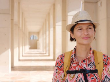 Abu Dabi 'de Qasr Al Hosn Parkı' nı keşfeden genç bir kadın. Yeşillik ve tarihi simgelerle çevrelenmiş, kentin kalbindeki sakin atmosfer ve Emirati mirasının tadını çıkarıyor..