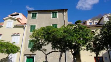 Krk, Hırvatistan - 30 Mart 2025. Hırvatistan 'ın batısındaki Primorje-Gorski İlçesi' nin Krk adasındaki Baska liman kasabası yakınlarındaki güzel eski evler