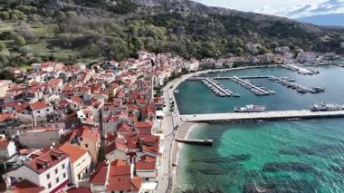 Baska plajı ve kristal berraklığında turkuaz su, marina botları, şehir sokağı, Krk Adası 'ndaki insansız hava aracından yakalanan güneşli yaz havası. Adriyatik Denizi 'ndeki Baska Tatil Kasabası