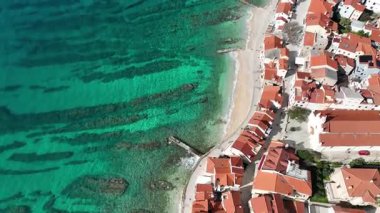 Baska plajı ve kristal berraklığında turkuaz su, marina botları, şehir sokağı, Krk Adası 'ndaki insansız hava aracından yakalanan güneşli yaz havası. Adriyatik Denizi 'ndeki Baska Tatil Kasabası