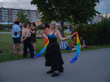 Prag, Çek Cumhuriyeti - 12 Ağustos 2023: Prag Onur Festivali Geçidi. Geçit töreninden sonra gökkuşağı kurdeleleriyle dans eden bir kadın.