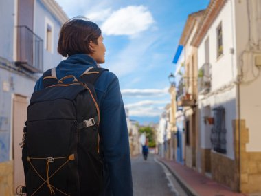 İspanya 'nın Alicante eyaletinin büyüleyici dar sokaklarında gezinen, tarihi Akdeniz mimarisi ile çevrili, barışçıl atmosfer ve kültürel ortamın tadını çıkaran genç bir kadın..