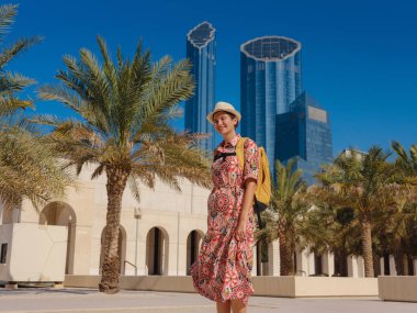 Abu Dabi 'de Qasr Al Hosn Parkı' nı keşfeden genç bir kadın. Yeşillik ve tarihi simgelerle çevrelenmiş, kentin kalbindeki sakin atmosfer ve Emirati mirasının tadını çıkarıyor..