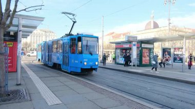 Zagreb, Hırvatistan - 13 Ocak 2025: Hırvatistan 'ın Zagreb kentindeki Main Train istasyonu veya Glavni Kolodvor yakınlarındaki sokak. Tramvaylı trafik, güneşli bir günde mavi bulutlu gökyüzü. Şehir taşımacılığı altyapısı.