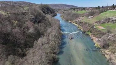 Korana Nehri 'nin insansız hava aracı manzarası Slunj yakınlarındaki engebeli arazide dönüyor. Ağaçlar kıştan dolayı hala çıplakken, berrak su ve yosunlu bankalar yaklaşan baharı ima ediyorlar. Hırvat doğası.