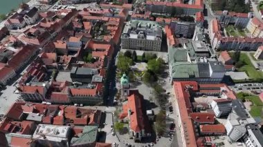 Slovenya, Maribor 'un güneşli bahar günündeki hava görüntüleri. Çatılar, şehir sokakları, tarihi binalar çiçek açan ağaçlar ve yeşil alanlarla çevrili, mükemmel bir kültür ve doğa karışımı sunuyorlar.