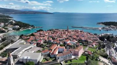 Krk Adası 'ndaki tarihi kıyı kasabası, dolambaçlı caddelerde, marinada ve şehir duvarlarında güneş ışığının Adriyatik Denizi' ne yansıdığı eski taş evler. Nefes kesici hava manzarası,