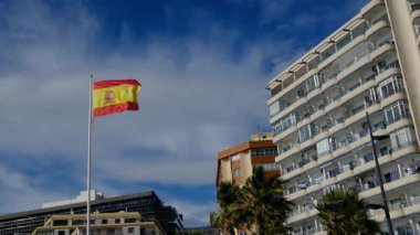 İspanyol bayrağı zarif bir şekilde Kalpe 'de mavi bir gökyüzüne doğru dalgalanıyor. Spains kültürel kimliğinin özünü yakalayan ulusal gurur, birlik ve mirasın güçlü bir sembolü.