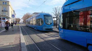 Zagreb, Hırvatistan - 13 Ocak 2025: Hırvatistan 'ın Zagreb kentindeki Main Train istasyonu veya Glavni Kolodvor yakınlarındaki sokak. Tramvaylı trafik, güneşli bir günde mavi bulutlu gökyüzü. Şehir taşımacılığı altyapısı.