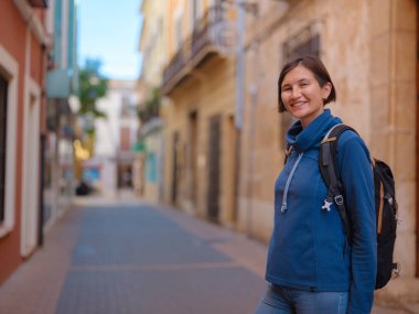 İspanya 'nın Alicante eyaletinin büyüleyici dar sokaklarında gezinen, tarihi Akdeniz mimarisi ile çevrili, barışçıl atmosfer ve kültürel ortamın tadını çıkaran genç bir kadın..