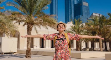 Abu Dabi 'de Qasr Al Hosn Parkı' nı keşfeden genç bir kadın. Yeşillik ve tarihi simgelerle çevrelenmiş, kentin kalbindeki sakin atmosfer ve Emirati mirasının tadını çıkarıyor..