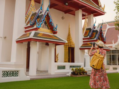 Bangkok 'taki Budist Tapınakları' nın yakınlarındaki Renkli Sokakları Keşfeden Kadın. Geleneksel mimari ve güzel Budist tapınaklarıyla çevrili Bangkok 'un büyüleyici sokaklarında gezen kadın gezgin..