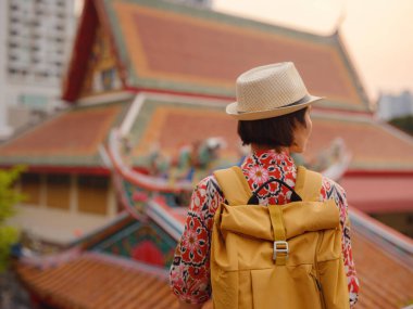 Bangkok 'taki Budist Tapınakları' nın yakınlarındaki Renkli Sokakları Keşfeden Kadın. Geleneksel mimari ve güzel Budist tapınaklarıyla çevrili Bangkok 'un büyüleyici sokaklarında gezen kadın gezgin..
