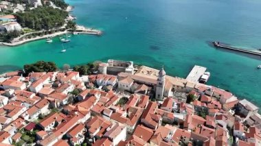 Krk Adası 'ndaki tarihi kıyı kasabası, dolambaçlı caddelerde, marinada ve şehir duvarlarında güneş ışığının Adriyatik Denizi' ne yansıdığı eski taş evler. Nefes kesici hava manzarası,