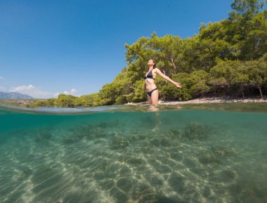 Denizde tropik tatil cennetinde bir kadın. Türk deniz kıyısında yaz tatili, Lycian Yolu 'nda plajlar, Türk Rivierası. Asyalı dişi su altı ve turkuaz okyanus çevresi.