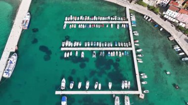 Baska plajı ve kristal berraklığında turkuaz su, marina botları, şehir sokağı, Krk Adası 'ndaki insansız hava aracından yakalanan güneşli yaz havası. Adriyatik Denizi 'ndeki Baska Tatil Kasabası