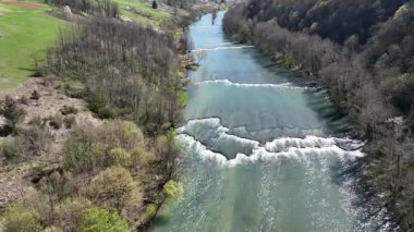Korana Nehri 'nin insansız hava aracı manzarası Slunj yakınlarındaki engebeli arazide dönüyor. Ağaçlar kıştan dolayı hala çıplakken, berrak su ve yosunlu bankalar yaklaşan baharı ima ediyorlar. Hırvat doğası.