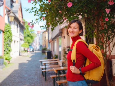 Turist kadın, Frankfurt yakınlarındaki Hochst 'un tarihi cazibesinden hoşlanıyor. Eski evler ve kaldırım taşlı sokaklarda geziniyor. Eski kasabanın huzurlu atmosferinde sırılsıklam oluyor..